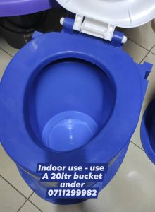 image of the toilet seat used indoors with a bucket under it
